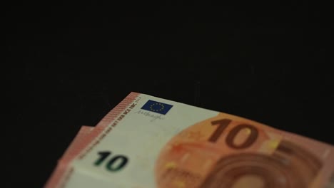 Banknotes-10-euro-slowly-falling-on-the-black-table.-Closeup.-Slow-motion