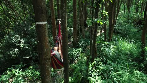 Vista-aérea-de-relajarse-en-la-hamaca-tomando-selfie-con-teléfono-inteligente-en-la-selva-tropical