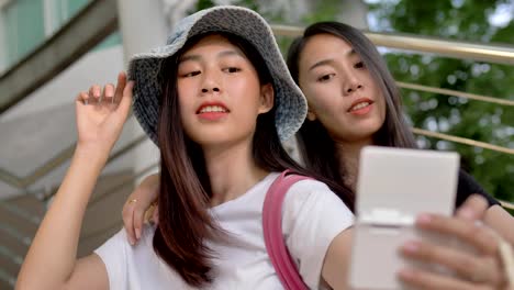 Glückliche-junge-asiatische-Mädchen-lächeln-und-Selfie-Foto-zur-Kamera