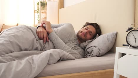 Man-waking-up-and-using-mobile-phone-in-bed