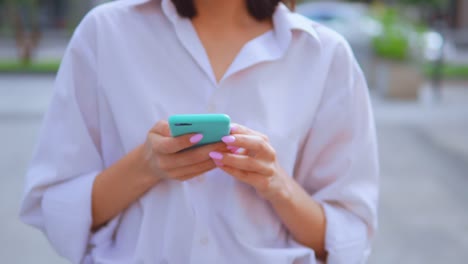 estrechar-las-manos-caucásica-mujer-sosteniendo-teléfono-inteligente-camina-fondo-de-la-ciudad-urbana