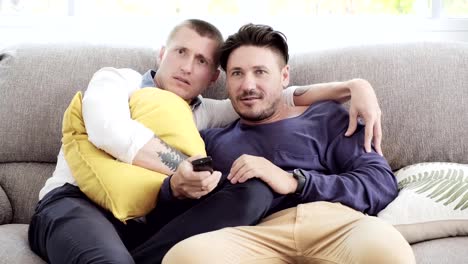 Pareja-gay-relajándose-en-el-sofá.-Disfrutar-viendo-la-televisión,-asustar-el-estado-de-ánimo.