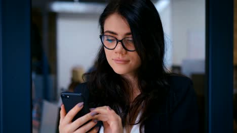 Porträt-der-schönen-jungen-Frau-mit-Smartphone-im-Büro.-Business-Lady-in-formalen-tragen-Kleid-Typing-Nachrichten-auf-ihrem-Handy.