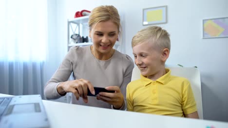 Glückliche-Mutter-und-Sohn-spielen-Spiele-auf-dem-Smartphone-zusammen,-Spaß,-App