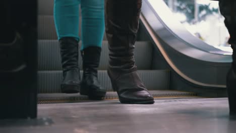 People's-Feet-go-Down-the-Escalator-Lift-in-the-Mall.-Shopper's-Feet-on-Escalator-in-Shopping-Center