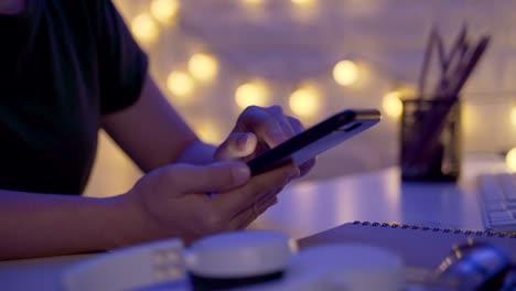 Close-up-shot-of-Female-hands-using-smart-phone-in-office-at-night.-Moving-camera-parallax-effect.