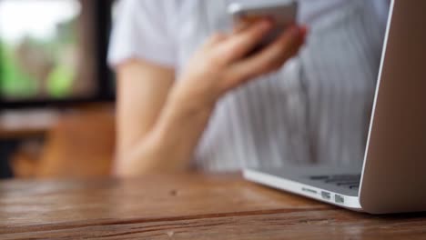 Woman-grab-smartphone-from-table-and-start-browsing-while-sitting-in-cafe