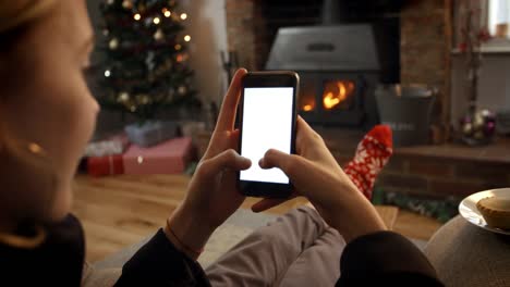 Mujer-en-línea-con-el-teléfono-móvil-en-habitación-listo-para-Navidad