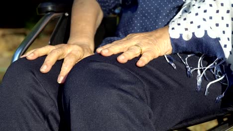 Elderly-woman-hand-on-wheelchair.