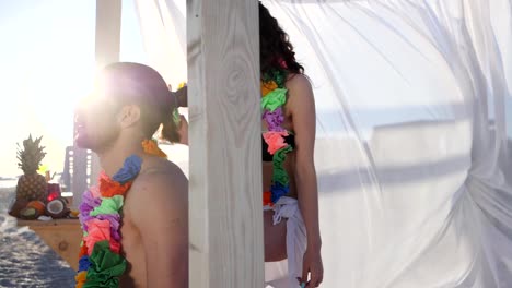 Shapely-girl-brought-for-man-cocktail-on-beach,-summer-vacation-young-couple-in-Hawaii,-girl-comes-to-guy-with-an-alcoholic-drink