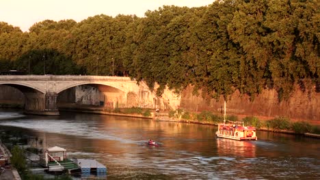 Boot-und-Kanu-auf-dem-Fluss-in-der-Nähe-der-Brücke,-umgeben-von-grünen-Bäumen-schweben