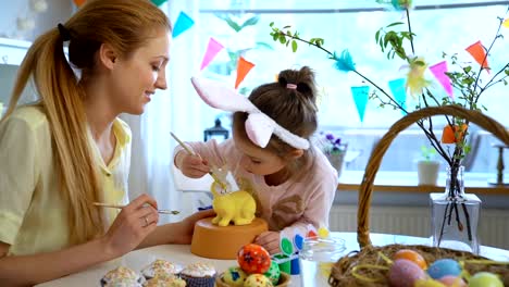 Madre-y-su-hija-pequeña-con-orejas-de-conejo-pintar-conejito-de-Pascua