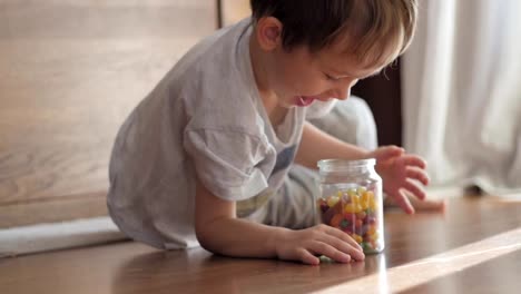 süsser-Boy-fangen-Glas-mit-Süßigkeiten