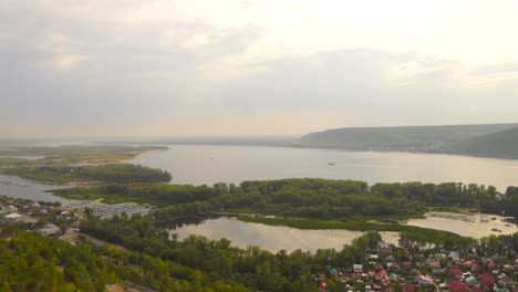 Coastal-view-of-islands-on-the-water-with-lots-houses-and-buildings.-Mountain-in-the-background.-Russia-Samara-river-Volga.