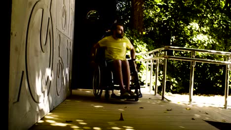 Disable-man-in-a-wheelchair-riding-down-the-inclined-plane