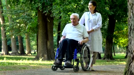 Arzt,-Krankenschwester,-Pflege-für-ältere-Menschen,-Mädchen-(Frau)-und-Großvater-in-einem-Rollstuhl-sitzt-im-Park-spazieren.