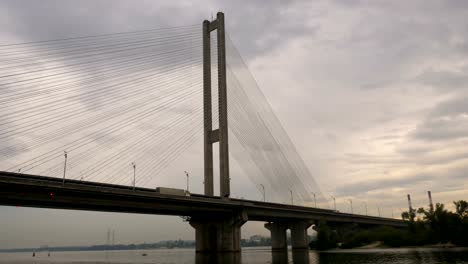 Große-Brücke-über-den-Fluss.-Architektonische-Gebäude-verbindet-die-beiden-Ufer-der-Stadt.-Massive-Struktur.-Über-die-Brücke-trägt-ein-LKW-Ladung.