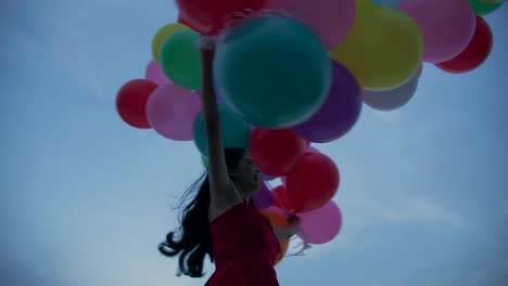 Girl-holding-balloon-with-sky-background-in-slow-motion.