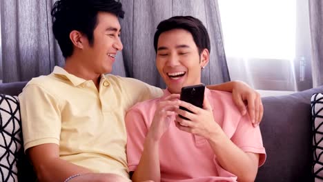 Gay-couple-using-smartphone-together-with-happy-emotion.-People-with-gay,-homosexual,-lifestyle-and-technology-concept.