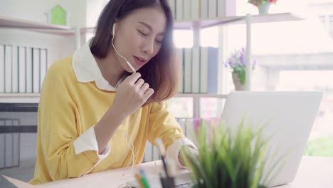 Beautiful-smart-business-Asian-woman-in-smart-casual-wear-working-on-laptop-and-talking-in-a-video-conference-on-line-with-a-headset-with-microphone-in-office.-Lifestyle-women-working-at-home-concept.