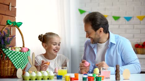 Father-and-daughter-hitting-each-others-with-egg,-Easter-eggs-tapping-tradition