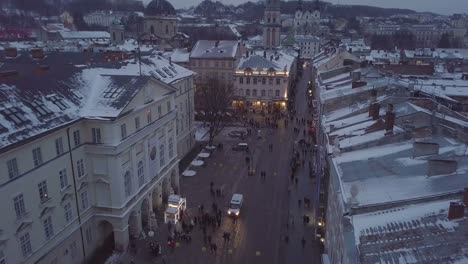 Lviv,-Ucrania---25-de-diciembre-de-2018.-Tiro-de-Arial.-Invierno.-Calle-plaza-Rynok.-Feria-de-Navidad.-Ayuntamiento-de-Lvov,-Consejo-de-la-ciudad.-Personas-están-caminando-en-el-centro-de-la-ciudad.-Adornos-navideños-y-luces.-Noche