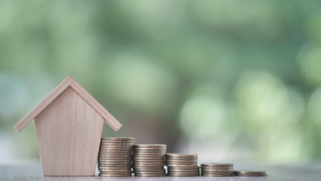 Money-coin-with-wooden-house-on-nature-background.-Property-investment-and-house-mortgage-financial,-Credit-home-concept-with-copy-space