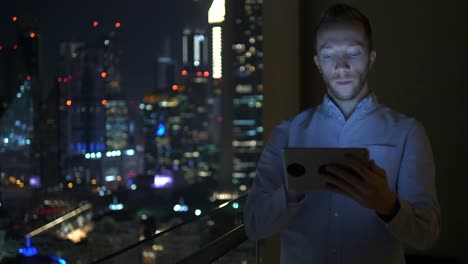 Caucasian-man-using-digital-tablet-for-internet-and-communications-with-cityscape-background