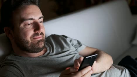 Happy-man-texting-on-mobile-phone-at-night