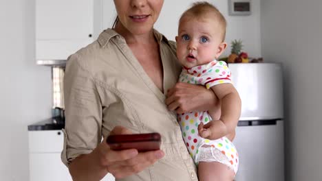 Crop-mother-with-baby-using-smartphone