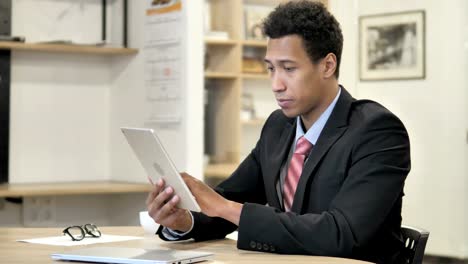 African-Businessman-Browsing-on-Tablet