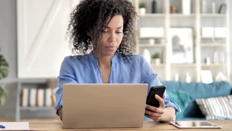 Mujer-africana-usando-smartphone-en-Workplace