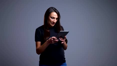 Closeup-portrait-of-pregnant-young-caucasian-woman-typing-on-the-tablet-in-front-of-the-camera