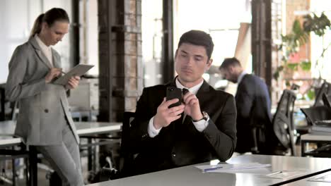 Businessman-Using-Smartphone-in-Office