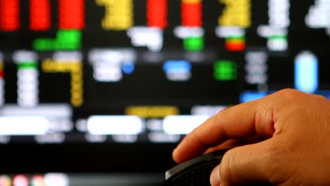 Man-clicking-mouse--to-monitoring--stock-exchange-board