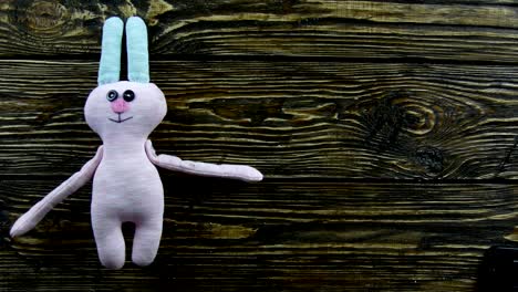 Toy-plush-hare-on-a-wooden-background