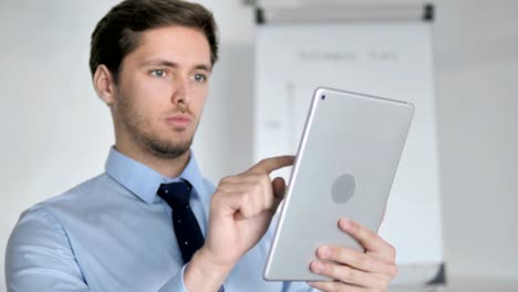 Close-Up-of-Young-Businessman-Using-Tablet-in-Office