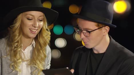 Freunde-nutzen-digitales-Tablet-und-Talking-auf-dem-Dach-in-der-Nacht