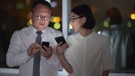 Coworkers-Browsing-the-Net-on-Smartphones-in-Dark-Office