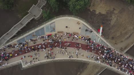 Eine-Menschenmenge-auf-einer-Fußgängerbrücke-ist-am-Frühlingsabend-zu-sehen.-Luftaufnahme.-Eine-neue-Fahrrad-Fußgängerbrücke-im-Zentrum-der-Hauptstadt-der-Ukraine,-der-Stadt-Kiew.-Ausflüge-und-Spaziergänge-für-Touristen