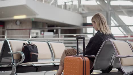 Frau-mit-digitalem-Gerät-am-Flughafen