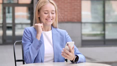 Joven-empresaria-emocionada-por-el-éxito-en-Smartphone