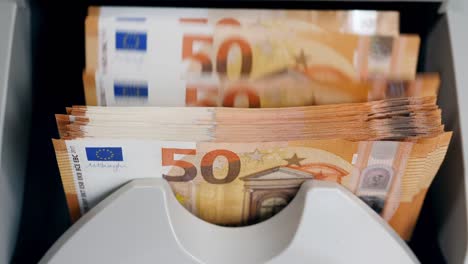 Orange-euro-bills-moving-in-a-counter-while-checked.