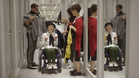 Friends-Helping-Woman-in-Wheelchair-Shopping-for-Clothes