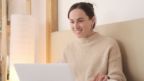 Frau-Video-chattet-auf-Laptop-im-Schlafzimmer