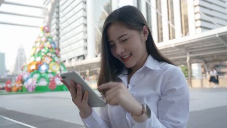 Excited-business-asian-woman-celebrating-good-news-checking-smart-phone-in-the-modern-city-center-in-the-evening-of-Bangkok-Thailand.-Concept-Technology-communication,-success-by-mobile-phone