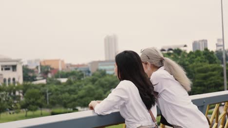 Asian-lesbian-couples-enjoying-traveling-and-talk-while-standing-on-the-bridge.-LGBT-concept.