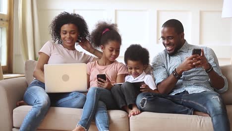 African-couple-and-little-kids-addicted-to-modern-gadgets