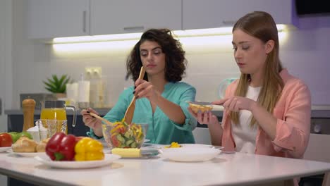 Schöne-Frau-serviert-Salat-zu-Freundin,-Frauen-beim-gemeinsamen-Frühstück