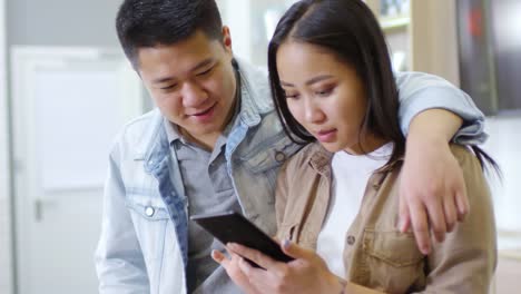 Asian-Couple-Using-New-Smartphone